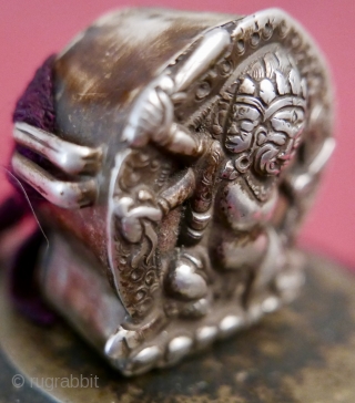 18th c. Tibetan Buddhist Silver Bhairava 'Gau' depicting Bhairava(Mahakala),  a fierce deity protector of Buddhist dharma;  copper backing,  efficacious for contact with the bare skin of the traveling lama;  ...