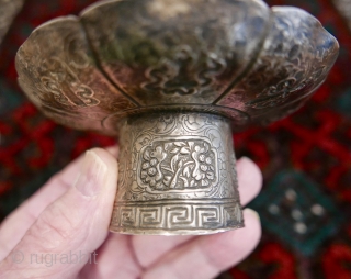 18th-19th c Tibetan silver teacup holder (dkar yol yu),  lid (kha leb)and cup (phor pa) with very finely chased and repousse-worked Buddhist auspicious symbols and a splayed lotus fineal surmounted by  ...