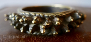 Lost-wax-cast brass bangle,  called a 'Virkangan',  or 'powerful hero' bangle;  worn by Shaivite ascetics.  Around the perimeter are symbols associated with Shiva:  the lingam;  the bull,  ...