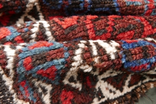 Mushwani Belouch/Baluch,  circa 1900,  2'10"x5'6",  wild and beautiful, with vivid red,  blue,  aubergine and white;  symmetrically knotted; kilim ends are complete except for small rough spot  ...