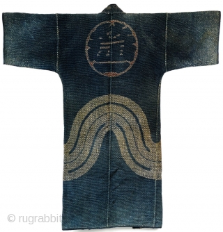 Heavy weight, densely stitched indigo dyed cotton. Tsutsugaki dyed cloth. Indigo background with red and white design on the reverse. Horizontal bands wrap around bottom of coat. Similar to reference work "Sumi  ...