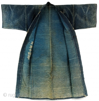 Heavy weight, densely stitched indigo dyed cotton. Tsutsugaki dyed cloth. Indigo background with red and white design on the reverse. Horizontal bands wrap around bottom of coat. Similar to reference work "Sumi  ...