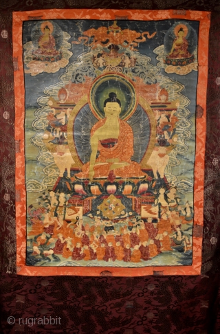 18th Century Thangka Depicting Shakyamuni Buddha, A stunning Tibetan thangka with Shakyamuni Buddha seated atop a lotus throne with hands in bhumisparsa mudra, surrounded by intricate narrative scenes with very fine details,  ...