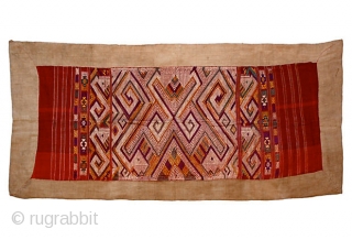 Tai Daeng Xieng Kuang Silk Embroidery
Handwoven and embellished silk on cotton brocade sleeping blanket from Laos. Geometric woven designs with red, purple, green, gold, and ivory brocade. 

74" L x 27.5" W  ...