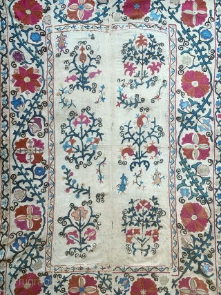 A lovely antique Uzbek silk suzani from 19th century rural Bukhara. It has fine polychrome silk chain-stitched embroidery on a cotton ground known as Karbos. The floral design is arranged in a  ...