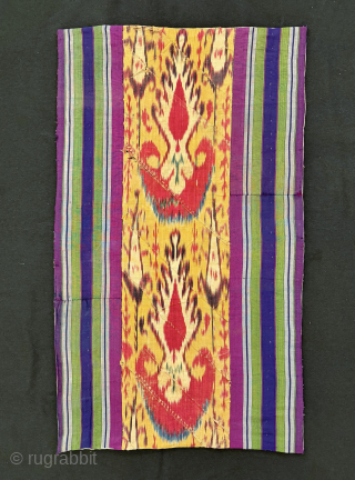 An outstanding antique silk warp / cotton weft Uzbek Adras early Ikat fragment hanging from Bukhara. All silk warp and cotton weft Adras Ikat. The central part, with a predominantly yellow ground,  ...