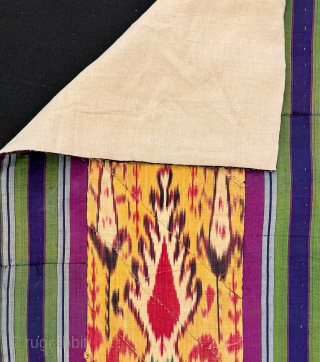 An outstanding antique silk warp / cotton weft Uzbek Adras early Ikat fragment hanging from Bukhara. All silk warp and cotton weft Adras Ikat. The central part, with a predominantly yellow ground,  ...