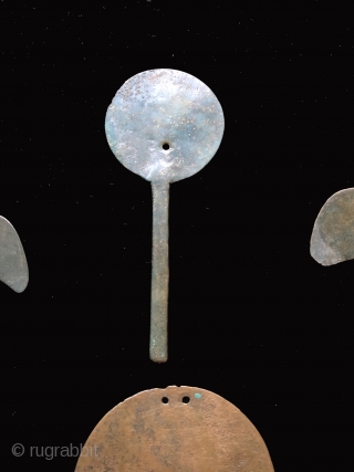 Collection of pre-conquest Andean bronze objects.  All date before c.1500.  Objects include a large circular disc shaped bronze pendant or shaman's mirror.  Various shaped pins for fastening textile garments.  ...