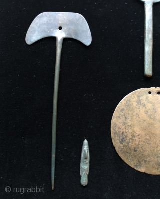 Collection of pre-conquest Andean bronze objects.  All date before c.1500.  Objects include a large circular disc shaped bronze pendant or shaman's mirror.  Various shaped pins for fastening textile garments.  ...