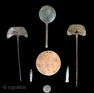 Collection of pre-conquest Andean bronze objects.  All date before c.1500.  Objects include a large circular disc shaped bronze pendant or shaman's mirror.  Various shaped pins for fastening textile garments.  ...