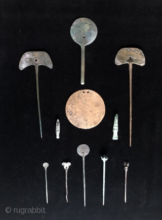 Collection of pre-conquest Andean bronze objects.  All date before c.1500.  Objects include a large circular disc shaped bronze pendant or shaman's mirror.  Various shaped pins for fastening textile garments.  ...