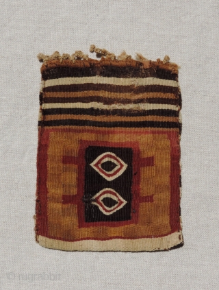 This small, finely woven Incan period tapestry bag has different designs on each face. It has a subtle checkerboard background with two coca leaf motifs or eye symbols worked in eccentric wefts  ...