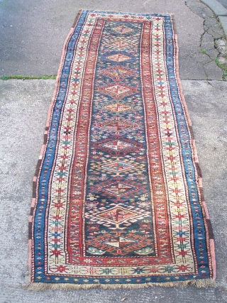 Karabagh runner - blue field with single column of hooked diamonds enclosed by ivory main border, early 20th.century; contains a synthetic pink-red (not the inner border colour but detailing in hooked diamonds  ...