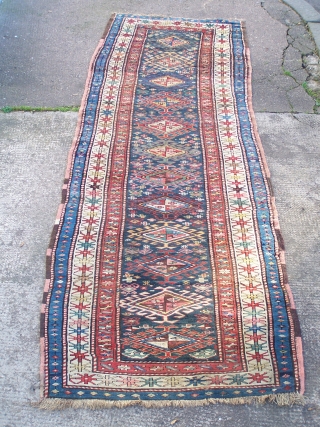 Karabagh runner - blue field with single column of hooked diamonds enclosed by ivory main border, early 20th.century; contains a synthetic pink-red (not the inner border colour but detailing in hooked diamonds  ...