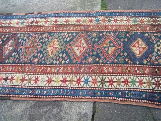 Karabagh runner - blue field with single column of hooked diamonds enclosed by ivory main border, early 20th.century; contains a synthetic pink-red (not the inner border colour but detailing in hooked diamonds  ...