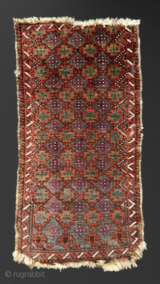 Antique Baluch balisht. Unusual palette, striking aubergine against a jade green and rust madder red. Fragmented ends and dense shimmering pile. A familiar design rendered with unusual minimalism and a distinctive array  ...