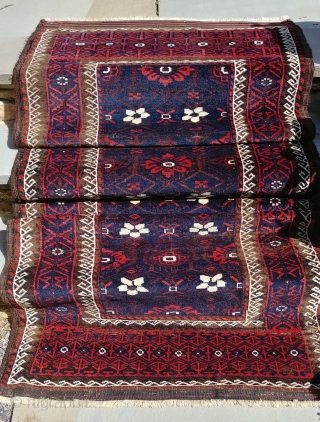 Antique Mina Khani Baluch. 254cm x 90 cm (8'3" x 3') Cherry red and deep navy blue. Unusual borders with long knotted elems.  Camel wefts.  Corroded blacks in the border.  ...