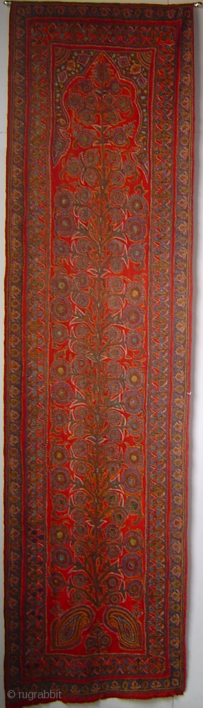 Kirman Tree under Arch embroidery, wool on fine red pashmina plain weave. 30 x 108 inches. Circa 1900.               