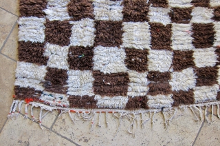 Azilal rug, middle Atlas mountain region of Morocco. Undyed cream and brown wool in a checker pattern on a cotton weft, with colorful boucherouite details of recycled cloth. Ca. 1980-1990. Has served  ...