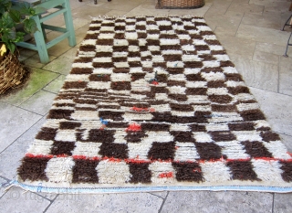 Azilal rug, middle Atlas mountain region of Morocco. Undyed cream and brown wool in a checker pattern on a cotton weft, with colorful boucherouite details of recycled cloth. Ca. 1980-1990. Has served  ...