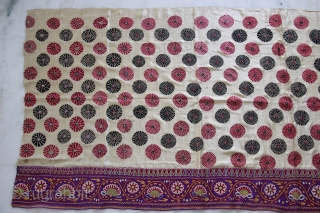 A full-sized embroidered cloth for a Chaniya (Skirt) from Kutch, Gujarat. The cloth is decorated with round flowers and the border with a colourful floral pattern all through the length of the  ...