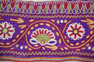 A full-sized embroidered cloth for a Chaniya (Skirt) from Kutch, Gujarat. The cloth is decorated with round flowers and the border with a colourful floral pattern all through the length of the  ...