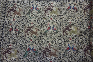 A black silk Dupatta decorated with Zari depicting birds perched on trees, tigers hunting deers, peacocks and peahens and warriors fighting on horseback and elephant back. The border, in turn, is decorated  ...