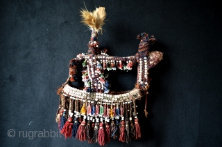 Beautiful Antique  Original Ethnografic Camelhead Trapping from one of the Baluch Tribes .Neck trapping is also available. Circa 1900. Nice original feather with many antique shell buttons and original tassels. Good  ...