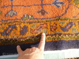 Old Oushak carpet. Over 95% full pile. Age-related wear, minor damage consistent with a roughly hundred year old antique. A couple of ragged areas at the outer border. There are a few,  ...