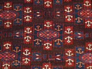 ANTIQUE YOMUT TURKMEN MAIN CARPET WITH KEPSE GUL DESIGN, CIRCA 1900.

Size: 10ft 8in x 6ft 8in (324 x 203cm).

The carpet has a rich brown ground colour with some very nice blues and  ...