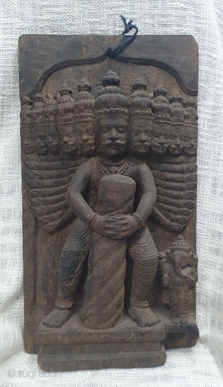 A wooden vintage decorative plaque probably a part of an architectural element showing Ravana holding a Shiva lingam with Ganesha on the side. (It is an episode from the story of Bajinath  ...