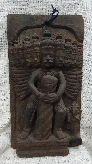 A wooden vintage decorative plaque probably a part of an architectural element showing Ravana holding a Shiva lingam with Ganesha on the side. (It is an episode from the story of Bajinath  ...