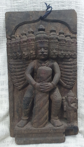 A wooden vintage decorative plaque probably a part of an architectural element showing Ravana holding a Shiva lingam with Ganesha on the side. (It is an episode from the story of Bajinath  ...