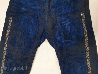 A Pair of velvet trousers in a luxurious blue colour. From Bengal.  India. Late 19th to early 20th century. The back has arrangements for suspenders with buckles made in Germany. The  ...