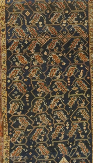 Antique Kurdish Rug circa 1900.An organic leaf design woven in brick  ivory and tan unfolds across the dark Persian blue central field.  A border holding four rows of intricate floral  ...