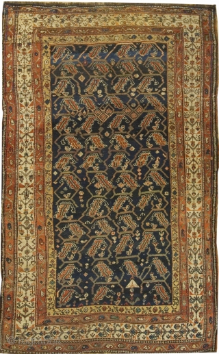 Antique Kurdish Rug circa 1900.An organic leaf design woven in brick  ivory and tan unfolds across the dark Persian blue central field.  A border holding four rows of intricate floral  ...