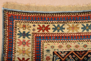 A small-format Kuba with a rare design. A repeat of flowers arranged into rows is seen in the dark brown field.19th Century Shirvan Kuba Rug The white-ground main border contains large star-shaped  ...