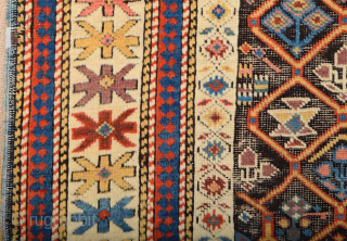 A small-format Kuba with a rare design. A repeat of flowers arranged into rows is seen in the dark brown field.19th Century Shirvan Kuba Rug The white-ground main border contains large star-shaped  ...