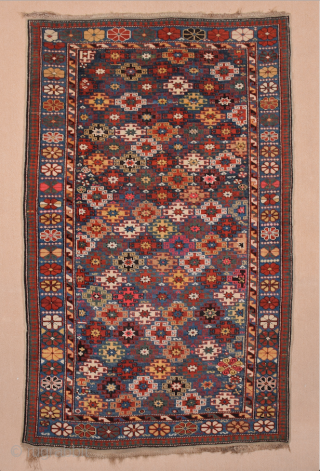 This immaculately drawn chichi displays the extra-wide border section that is typical of the provenance; the narrow midnight blue field contains a repeat of hooked stepped polygons and small octagons, incorporated into  ...