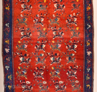 South Caucasian Karabagh Rug. In the Red field, short stems arranged in parallel rows combine into a dense repeat in shades of green, red and pink. Each stem bears a large blossom.  ...