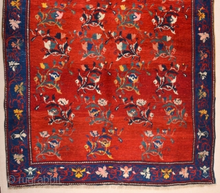 South Caucasian Karabagh Rug. In the Red field, short stems arranged in parallel rows combine into a dense repeat in shades of green, red and pink. Each stem bears a large blossom.  ...
