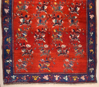 South Caucasian Karabagh Rug. In the Red field, short stems arranged in parallel rows combine into a dense repeat in shades of green, red and pink. Each stem bears a large blossom.  ...