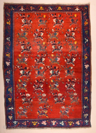 South Caucasian Karabagh Rug. In the Red field, short stems arranged in parallel rows combine into a dense repeat in shades of green, red and pink. Each stem bears a large blossom.  ...