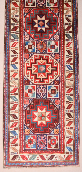 19th Century This very beautiful long rug from the Genje area presents a field design of polychrome diagonal stripes decorated with small usual medallion motifs. The distribution of the colours in the  ...