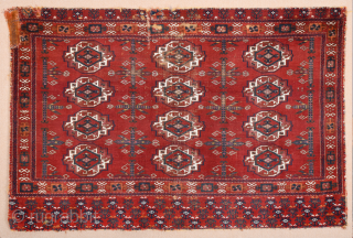 Central Asia West Turkestan Early 19th Century Saryk.This large Saryk Chuval displays twelve primary güls and chemche secondary designs in a dark red field. The main border contains diagonal crosses and hooked  ...