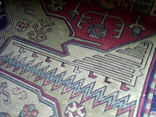 I was gifted a large Caucasian Carpet,it is made of wool, I'm not sure what tribe made this piece ,it has numerous symbols ,rolling water, hands on hips, the dragon, the S,rosettes,wheel,swastika  ...