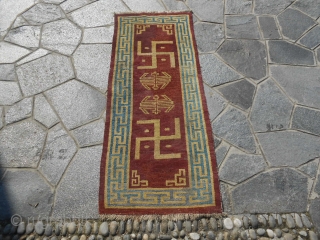 161 x 66 cm.  This is an antique TIBETAN carpet from Lahsa. Wool on wool original colours and vegetable dyes. Ideogram shou, pearls, svastika and dragon patter in the 4 corners,  ...