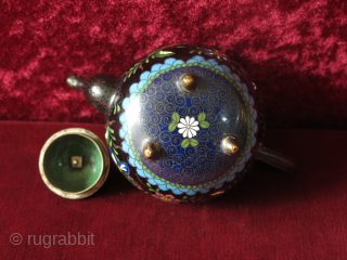 Antique Meiji era Japanese Cloisonne footed teapot. The teapot’s body is decorated all over with scrolling foliage and multicolored butterflies, flowers on a black background while the spout and the base are  ...