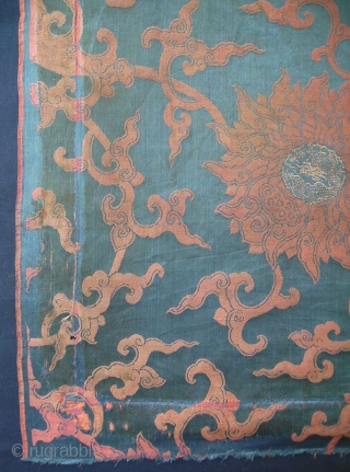 A large size panel of brocaded silk with a pattern of winding flowers. In the hearts of the flowers a climbing dragon. Late Ming or early Qing, ca. 1650. Full width with  ...