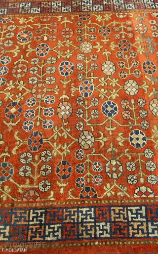 Antique Khotan Rug, 19th Century,

The abrashed rust field with overall design of angular polychrome rosette and leafy vine. In   multicoloured open and linked squares containing Buddhist motifs between barber-pole and  ...